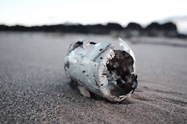 Paslı metal soda kutusu çöpü güneşli, kumlu, lüks bir plaj varış yerine vurmuş. Çevresel metal kirliliği dünya haberlerine neden oluyor. Dünyanın dört bir yanındaki kıyılarda sağlık felaketi.                              