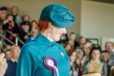 Morecambe, İngiltere, 05 / 05 / 2017, Mavi şapkalı ve klasik şablonlu bir kadın aqua blue americana 1950 'lerin bluzu, klasik moda kadın oyunculuğu ve şık kostümlü poz.