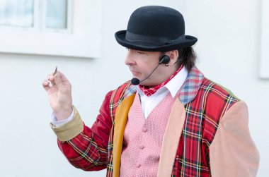 Londra, İngiltere, 15 / 03 / 2019 Şehir sokaklarında çocukları eğlendiren bir büyüteçle bit sirki göstericisi. Geleneksel pire sirk müdürü komik adam..