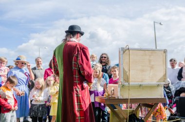 Londra, İngiltere, 15 / 03 / 2019 Şehir sokaklarında çocukları eğlendiren bir büyüteçle bit sirki göstericisi. Geleneksel pire sirk müdürü komik adam..