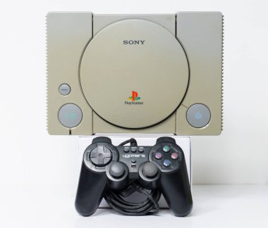 Londra, İngiltere, 07 / 05 / 2018 1994 'ten orijinal Sony Playstation konsolu. PS1 retro video oyun konsolu. Eski ve rengi değişmiş eski bir konsol. Sonys oyun donanım birimi beyaz arkaplanda izole.