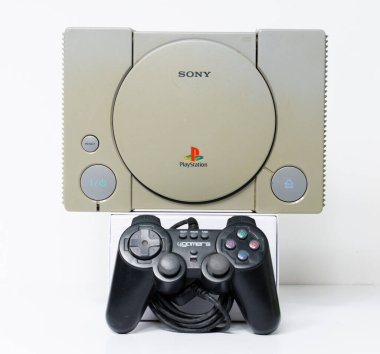 Londra, İngiltere, 07 / 05 / 2018 1994 'ten orijinal Sony Playstation konsolu. PS1 retro video oyun konsolu. Eski ve rengi değişmiş eski bir konsol. Sonys oyun donanım birimi beyaz arkaplanda izole.