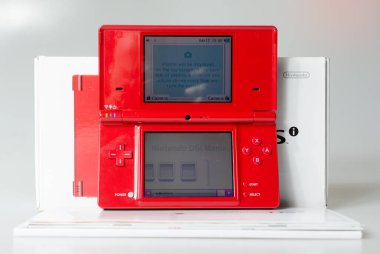 Lodnon, İngiltere, 05 / 05 / 2019 Beyaz bir stüdyo arka planında kırmızı bir Nintendo 'nun el yapımı vintage konsolu. Retro video oyun ahizesi. Nostaljik bilgisayar ve atari oyunları. 