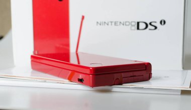 Lodnon, İngiltere, 05 / 05 / 2019 Beyaz bir stüdyo arka planında kırmızı bir Nintendo 'nun el yapımı vintage konsolu. Retro video oyun ahizesi. Nostaljik bilgisayar ve atari oyunları. 