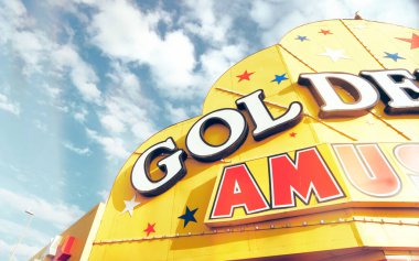 İngiltere 'nin Blackpool kentindeki sahil şeridinde açık mavi gökyüzüne karşı parlak sarı bir kumar salonu tabelası. Altın sarısı ve kırmızı. Mutlu çocukluk anıları.                        