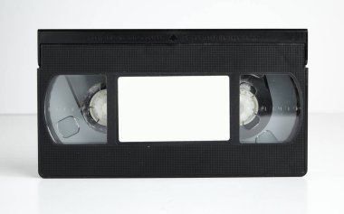 Beyaz zemin üzerinde boş etiket, tipografi ya da grafikler olan eski bir retro vhs kaseti. 1980 'lerin nostaljik video klibi. eskimiş ortam biçimi.