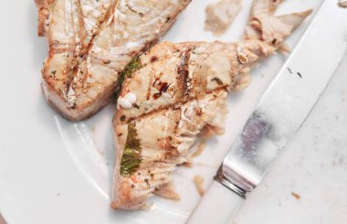 Mükemmel pişirilmiş organik tavada kurutulmuş ton balığı ve somon bifteği. Beyaz bir tabakta servis ediliyor. Sağlıklı beslenme için taze taze balık. Besleyici ve lezzetli düşük yağlı deniz ürünleri..