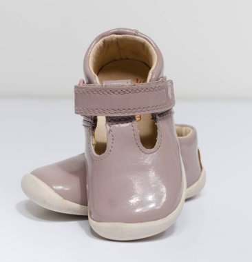 Beyaz stüdyo arka planında izole edilmiş şirin, eski, pembe bebek bebek bebek ayakkabıları. Bebek partisi için küçük bebek ayakkabıları. Bebekler hızlı büyür..