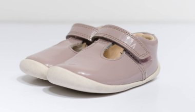 Beyaz stüdyo arka planında izole edilmiş şirin, eski, pembe bebek bebek bebek ayakkabıları. Bebek partisi için küçük bebek ayakkabıları. Bebekler hızlı büyür..