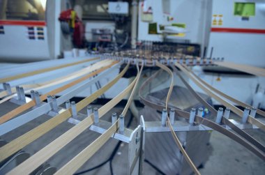Londra, İngiltere, 05 / 02 / 2018 Bir fabrika ortamında otomatik laminate kenar budama makinesi. Bitmiş bir görünüm ve tahta için mobilya köşesi kaplamaları. Sert giyimli düz paket mobilya köşesi