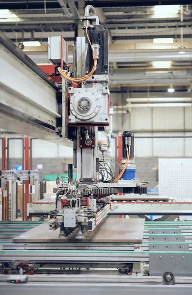 Industrial automated robot machinery in an industrial workshop factory environment. Automated machinery taking jobs away from humans. Machines versus humans. mass production for corporate profits.