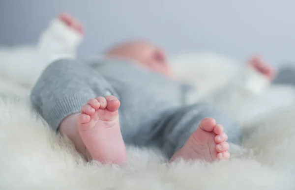 A beautiful soft delicate warm young baby foot photographed with a shallow depth of field. gentle calm colours and feel. baby care and well being. babies feet.