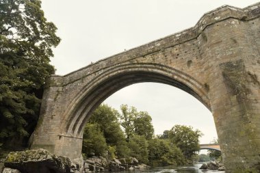 Lancashire, İngiltere, 05 / 05 / 2019 Dünyaca ünlü Şeytanlar Köprüsü, bir ortaçağ tuğla köprüsü. Tarihi dönüm noktası. İnsanlar eğlence ve eğlence için bu köprüden atlıyor. Geçmişi olan bir köprü.