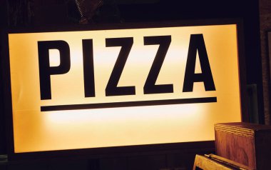 Moda ikonik sinematik yazı tipi New York pizza tabelası eski moda hipster pizza restoranının içinde. Pizzacı tarzı pizza tezgahını aç..                   