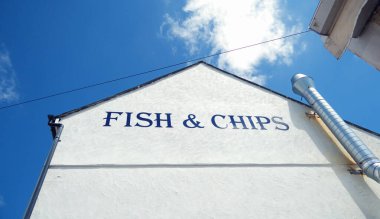 Geleneksel İngiliz deniz kıyısı balık ve patates kızartması tabelası ve binası. İngiliz deniz kenarındaki fast food dükkanı. Harfler ve işaretler. İngiliz yemek restoranı. 