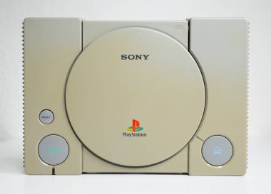 Londra, İngiltere, 07 / 05 / 2018 1994 'ten orijinal Sony Playstation konsolu. PS1 retro video oyun konsolu. Eski ve rengi değişmiş eski bir konsol. Sonys oyun donanım birimi beyaz arkaplanda izole.