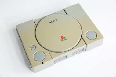 Londra, İngiltere, 07 / 05 / 2018 1994 'ten orijinal Sony Playstation konsolu. PS1 retro video oyun konsolu. Eski ve rengi değişmiş eski bir konsol. Sonys oyun donanım birimi beyaz arkaplanda izole.