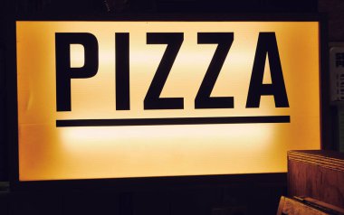 Moda ikonik sinematik yazı tipi New York pizza tabelası eski moda hipster pizza restoranının içinde. Pizzacı tarzı pizza tezgahını aç..                   