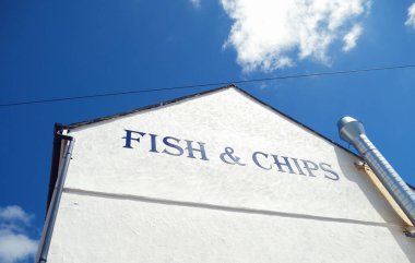 Geleneksel İngiliz deniz kıyısı balık ve patates kızartması tabelası ve binası. İngiliz deniz kenarındaki fast food dükkanı. Harfler ve işaretler. İngiliz yemek restoranı. 