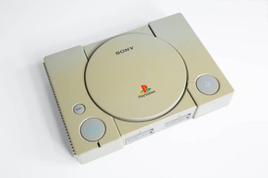 Londra, İngiltere, 07 / 05 / 2018 1994 'ten orijinal Sony Playstation konsolu. PS1 retro video oyun konsolu. Eski ve rengi değişmiş eski bir konsol. Sonys oyun donanım birimi beyaz arkaplanda izole.