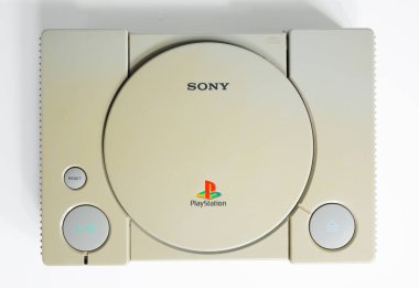 Londra, İngiltere, 07 / 05 / 2018 1994 'ten orijinal Sony Playstation konsolu. PS1 retro video oyun konsolu. Eski ve rengi değişmiş eski bir konsol. Sonys oyun donanım birimi beyaz arkaplanda izole.