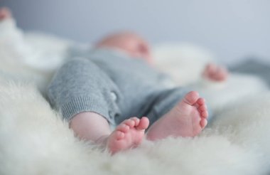 Sığ bir tarlada çekilmiş güzel, yumuşak, narin, genç bir bebek ayağı. Sakin renkler ve hisset. Bebek bakımı ve refah. bebek ayakları.