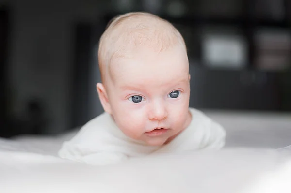 Roztomilé dítě na bílé posteli — Stock fotografie