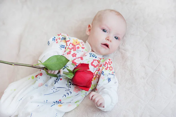 Χαριτωμένο μωρό κορίτσι κρατώντας ένα μπουκέτο λουλούδια τριαντάφυλλο — Φωτογραφία Αρχείου
