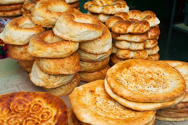 ウズベキスタン国立パン。古いストーブで焼いた伝統的な東部白い平らなパン. — ストック写真