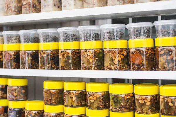 Glazen potten met noten en honing op teller in een markt als de achtergrond — Stockfoto