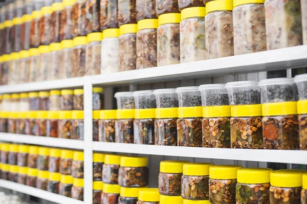Glazen potten met noten en honing op teller in een markt als de achtergrond — Stockfoto