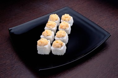 Suşi maki ton balığı ile siyah plaka üzerinde set. Japon yemekleri üzerinde arka izole