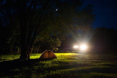 Turist gece kamp. Romantik Çift turist inanılmaz gece gökyüzü yıldızlarla dolu altında ışıklı çadır yakınındaki bir kamp ateşi, dinlen. 