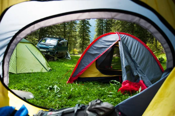 View looking out of door of sun-filled tent upon great outdoors scenery. Morning in the tent camp