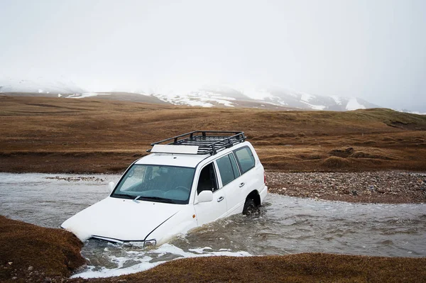 Accident on the road, car crash. Off-road expedition. Jeep 4x4 stuck in mountain river stream. The car drowned in the river. Extreme dangerous journey. Adventures in transit