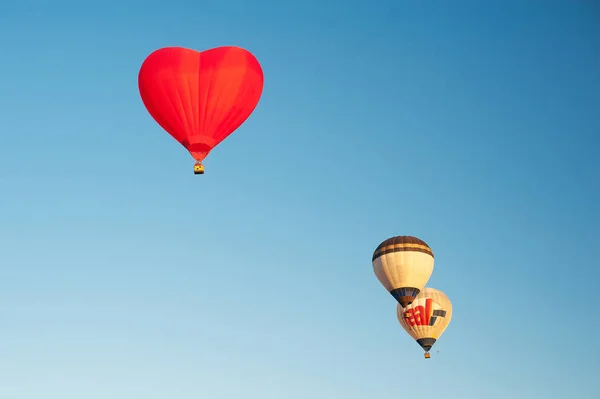 Tre mongolfiere nel cielo azzurro. Aerostat sul paesaggio campo . — Foto Stock