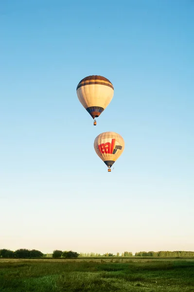 Dos globos de aire caliente en el cielo azul claro. Aerostato sobre el paisaje de campo . —  Fotos de Stock