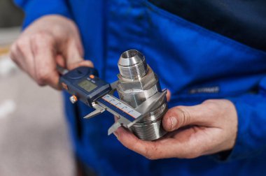Doğru bir ölçüm cihazı mekanizmasındaki bir parçası ölçme bir işçi el close-up. Elektronik Kaliper