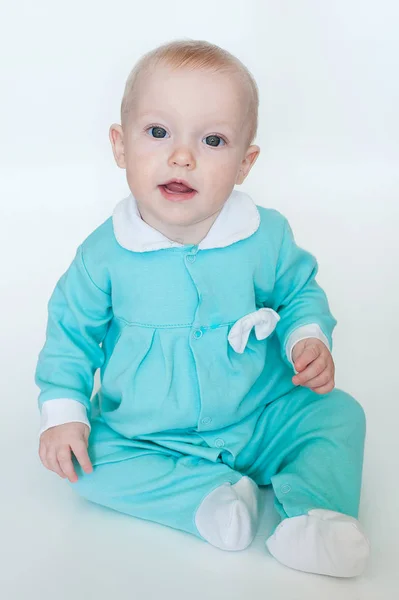 Aranyos vicces kis baba lány türkiz kezeslábas elszigetelt fehér background. — Stock Fotó