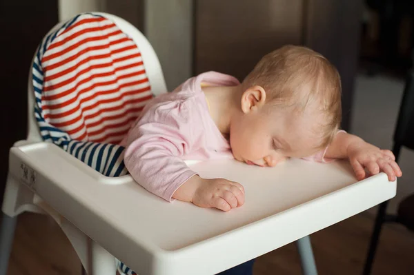 Yorgun çocuk sandalyesi öğle yemeğinden sonra uyuyor. Yeme ve sadece besleme sonra uykuda fall şirin bebek kız yüzünü tablo tepsi üzerinde yalan.