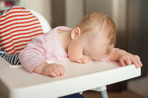 Yorgun çocuk sandalyesi öğle yemeğinden sonra uyuyor. Yeme ve sadece besleme sonra uykuda fall şirin bebek kız yüzünü tablo tepsi üzerinde yalan.