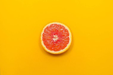 En az tarzı, yaratıcı düzen portakal ve greyfurt. Düz yatıyordu. Gıda kavramı. Yarısı turuncu sarı zemin üzerine.