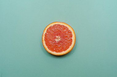 En az tarzı, yaratıcı düzen portakal ve greyfurt. Düz yatıyordu. Gıda kavramı. Turkuaz arka plan üzerinde yarım portakal.