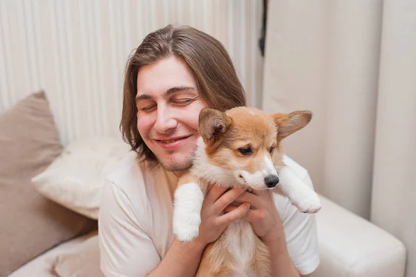 Glücklich lächelnde Männer kuscheln sich mit einem Welpen-Corgi — Stockfoto