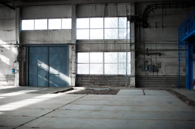 Üretim Fabrikası. Boş hangar binası. Mavi tonlu arka plan. Büyük pencereler ve metal yapılar ile üretim Oda