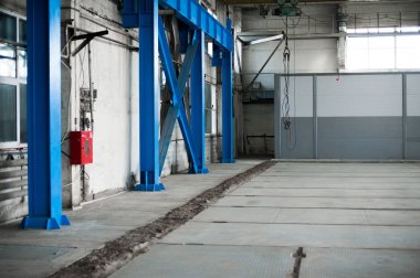 Üretim Fabrikası. Boş hangar binası. Mavi tonlu arka plan. Büyük pencereler ve metal yapılar ile üretim Oda