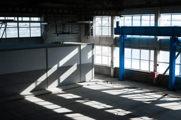Fábrica de fabricación. Edificio del hangar vacío. Fondo tonificado azul. La sala de producción con grandes ventanales y estructuras metálicas — Foto de Stock