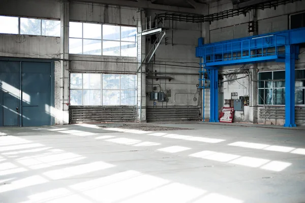 Fertigungsfabrik. Leere Hangargebäude. blaugetönter Hintergrund. der Produktionsraum mit großen Fenstern und Metallkonstruktionen — Stockfoto