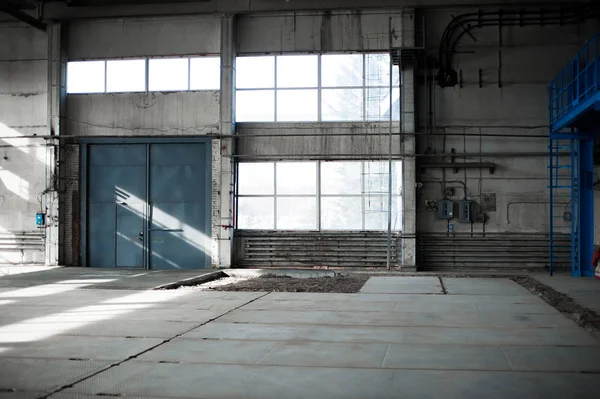 Fabbrica manifatturiera. Edificio vuoto dell'hangar. Sullo sfondo blu. La sala di produzione con grandi finestre e strutture metalliche — Foto Stock