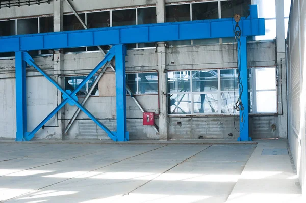 Výrobní továrny. Budova prázdný hangár. Modré pozadí tónovaný. Výrobní prostor s velkými okny a kovových konstrukcí — Stock fotografie